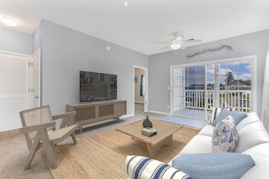 Carpeted living area featuring a ceiling fan and baseboards (Virtually Staged)