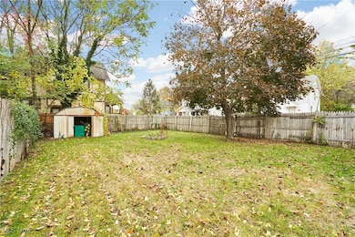 Fenced backyard featuring a storage shed