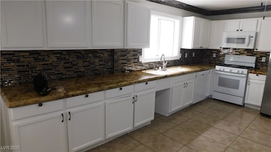 Kitchen  tile floors, tasteful backsplash, and whi