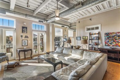 Living room filled with light from the double french doors and large windows.