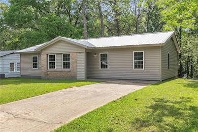 Single story home with driveway, a front yard, and