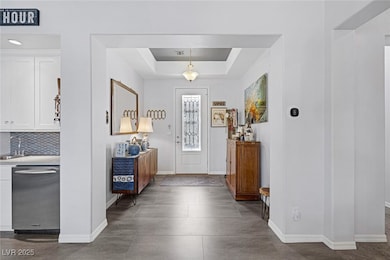 Foyer featuring baseboards and a tray ceiling