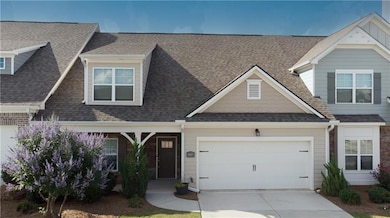 View of front of house featuring concrete driveway, a garage, and a shingled roof