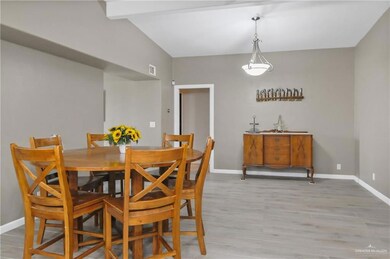 Dining room featuring light hardwood / wood-style flooring and vaulted ceiling with beams