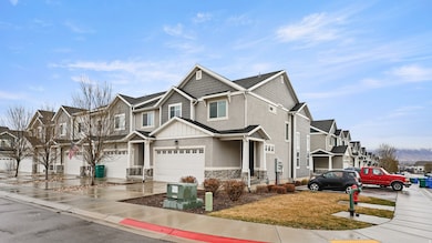 View of front of property featuring stone siding, a residential view, concrete driveway, stucco siding, and a garage