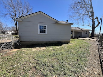 View of side of home with a yard, fence, and a pat