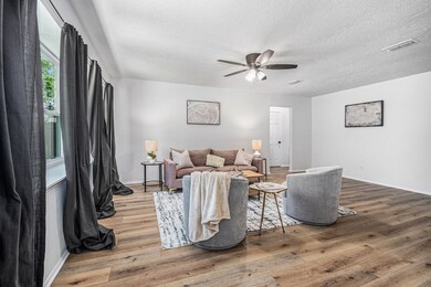 Large living area with new floors and lighting.