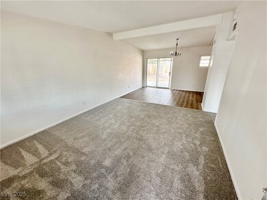 Unfurnished room with carpet flooring and a chande