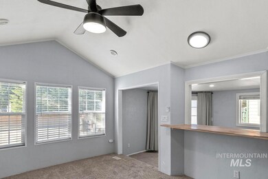 Unfurnished living room with carpet, healthy amount of natural light, lofted ceiling, and a ceiling fan