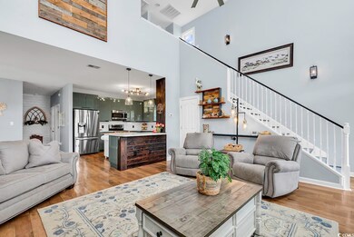 Living room with ceiling fan with notable chandeli