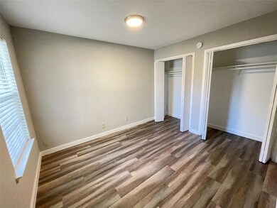 Unfurnished bedroom featuring baseboards, dark wo