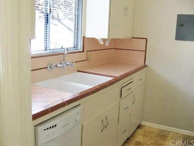 Cozy kitchen with tile counters, double sink, dish