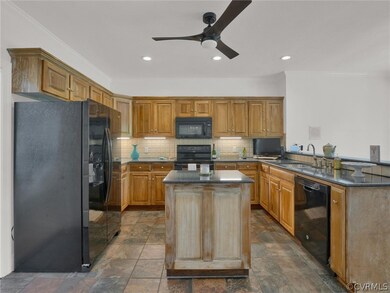 Kitchen featuring black appliances, ceiling fan, d