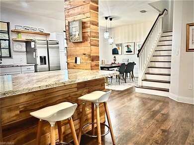 Bar with stairs, stainless steel fridge, pendant l