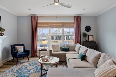 Living area with a ceiling fan, crown molding, bas