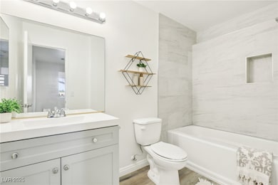 Bathroom featuring toilet, vanity, baseboards, and