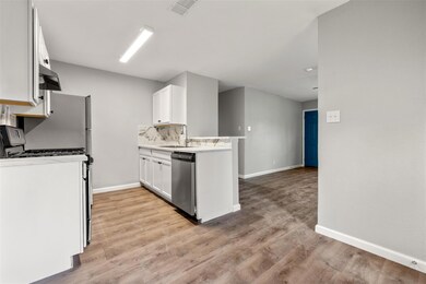 Kitchen with dishwasher, stove, light countertops