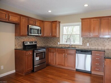 Kitchen has granite countertops and wood flooring.