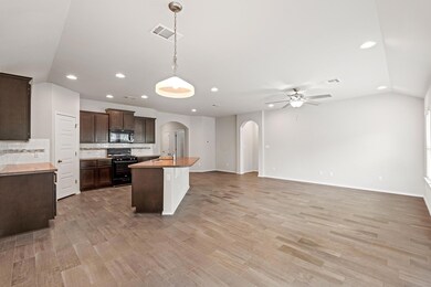 Kitchen with black appliances, arched walkways, r