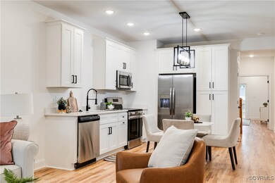 Kitchen with white cabinets, sink, hanging light f