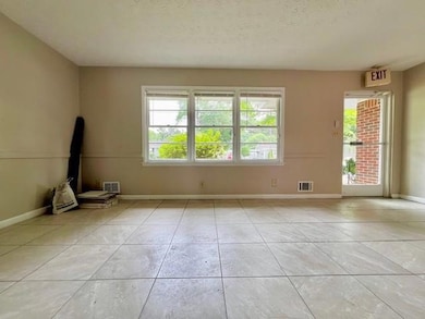 Spare room featuring healthy amount of natural light, light tile patterned floors, and a textured ceiling