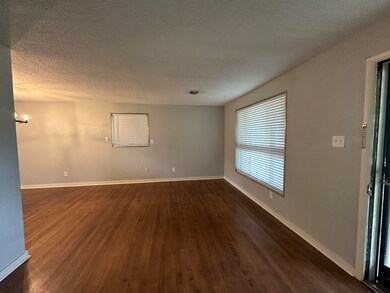 Empty room featuring dark wood-style floors, a tex