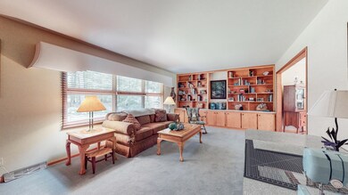 The living room is located just off the foyer and offers built-in shelving and cabinetry