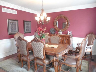 Dining room with wainscoting, crown molding, and a