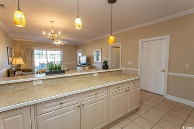 Kitchen with ornamental molding, pendant lighting,