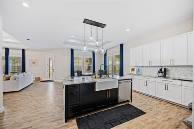 Kitchen with a tray ceiling, dishwasher, a sink, 