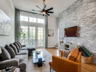 Living room featuring baseboards, ceiling fan, woo