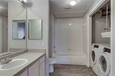 Full bath featuring shower / tub combination, vanity, light wood finished floors, and washing machine and dryer