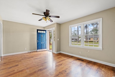 Foyer with wood finished floors, visible vents, ba