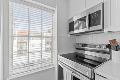 Kitchen with tasteful backsplash, light counterto