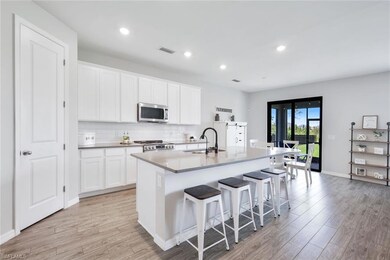 Kitchen featuring white cabinetry, sink, light har