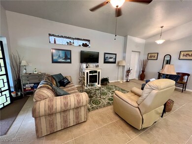 Living room featuring ceiling fan, light tile patt