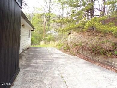 CONCRETE PAD BEHIND HOME WITH RETAINING