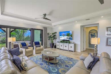 Living room with a tray ceiling, a ceiling fan, ornamental molding, light wood-style flooring, and recessed lighting
