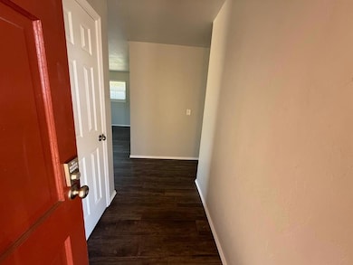Hallway with baseboards and dark wood-style floors