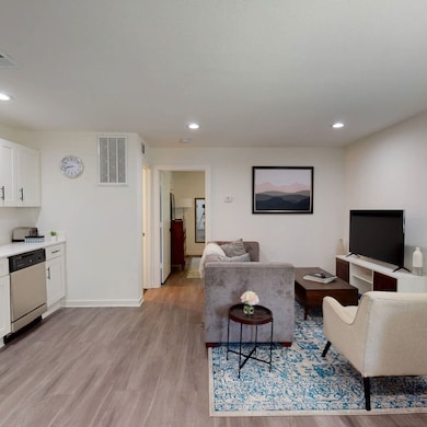 Living room with light wood finished floors and recessed lighting