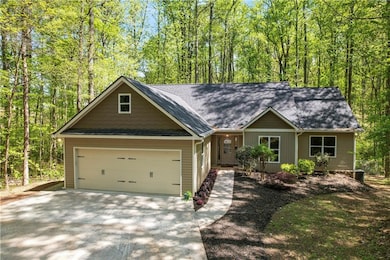 View of front of home featuring driveway, a garage, and roof with shingles