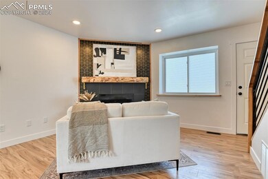 Living room with a tiled fireplace and light hardw