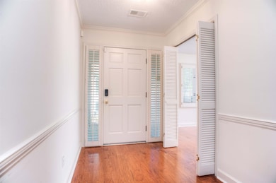 Welcoming Entry Hall with Rich Hardwood Flooring and   Plantation Shutters, Setting the Tone for the Home’s   Elegant Design.