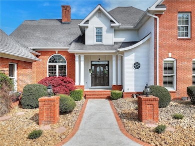Doorway to property featuring brick siding, roof w