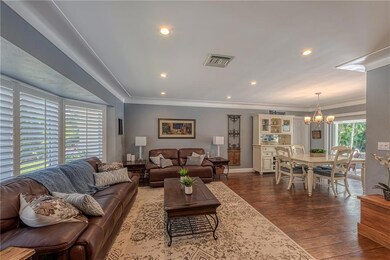 Large family room with plantation shutters and woo