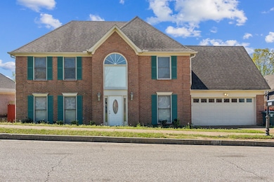 Colonial-style house with a garage, brick siding, 