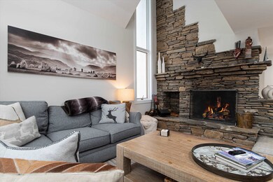 Dry lay stone woodburning fireplace highlighted by floor to ceiling sidelights