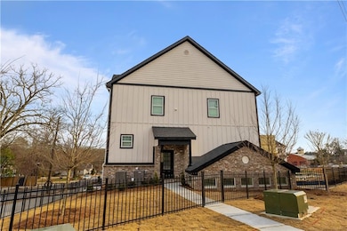 View of front of home featuring a fenced front yard, brick siding, and board and batten siding