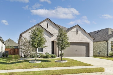 French country home with brick siding, concrete driveway, and an attached garage