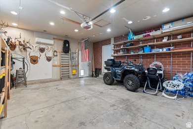 Garage with recessed lighting, a garage door opener, and a wall mounted air conditioner